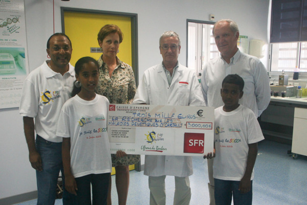 De Gauche à droite : Ibrahim Ingar, Président de 1000 Sourires, Caroline Gaudel - Direction Marketing SFR, Docteur François Cartault - Chef du service de génétique au CHU "Félix Guyon" - Bertrand Guillot, Directeur Général SFR Réunion, les 5000èmes enfants parrainés : Cynthia et Josélito